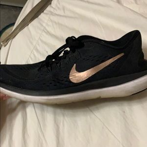 Woman’s gold and black sneakers